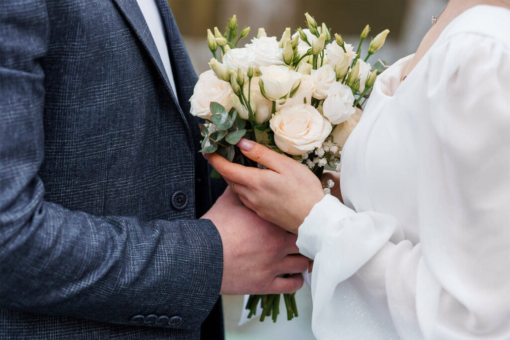 Elegant Wedding Couple Holding a Beautiful Bouquet of White and Green Flowers