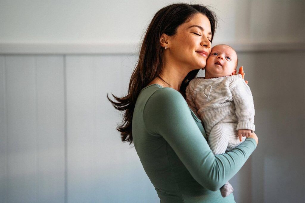 Happy mother hugging her newborn baby