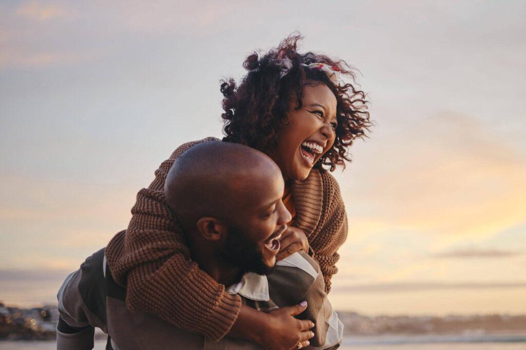 couple travel and beach fun while laughing on sunset