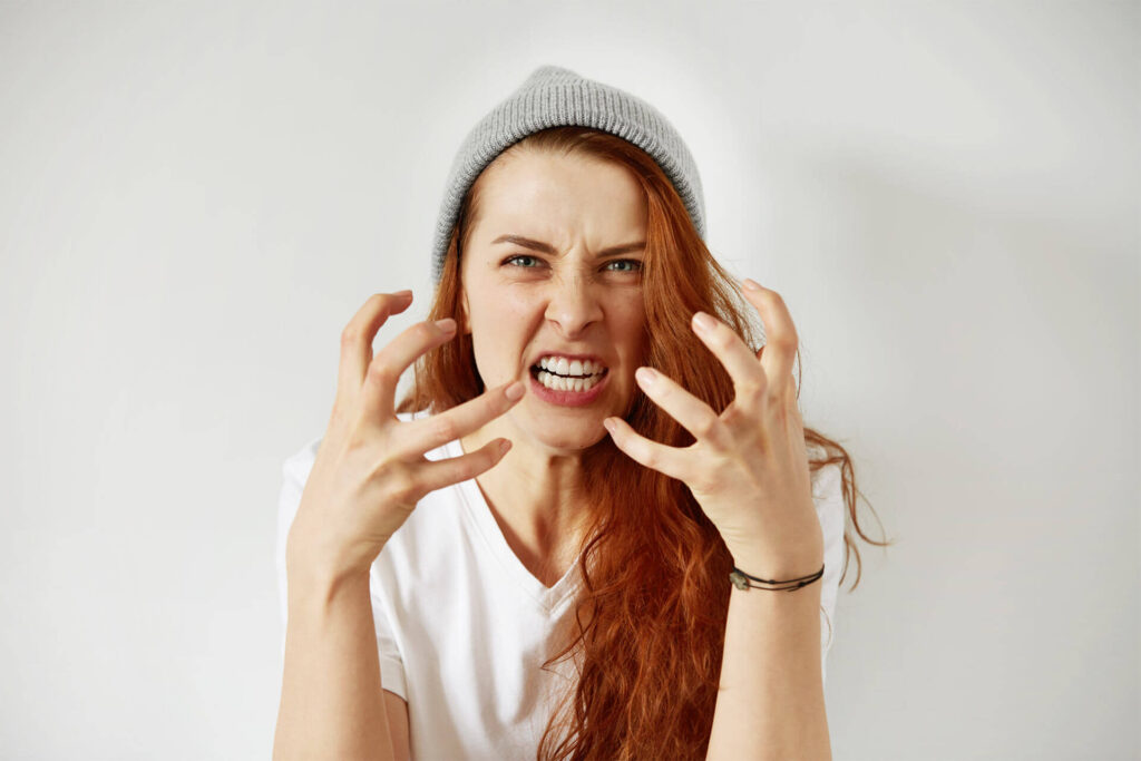 young annoyed woman holding hands in furious gesture