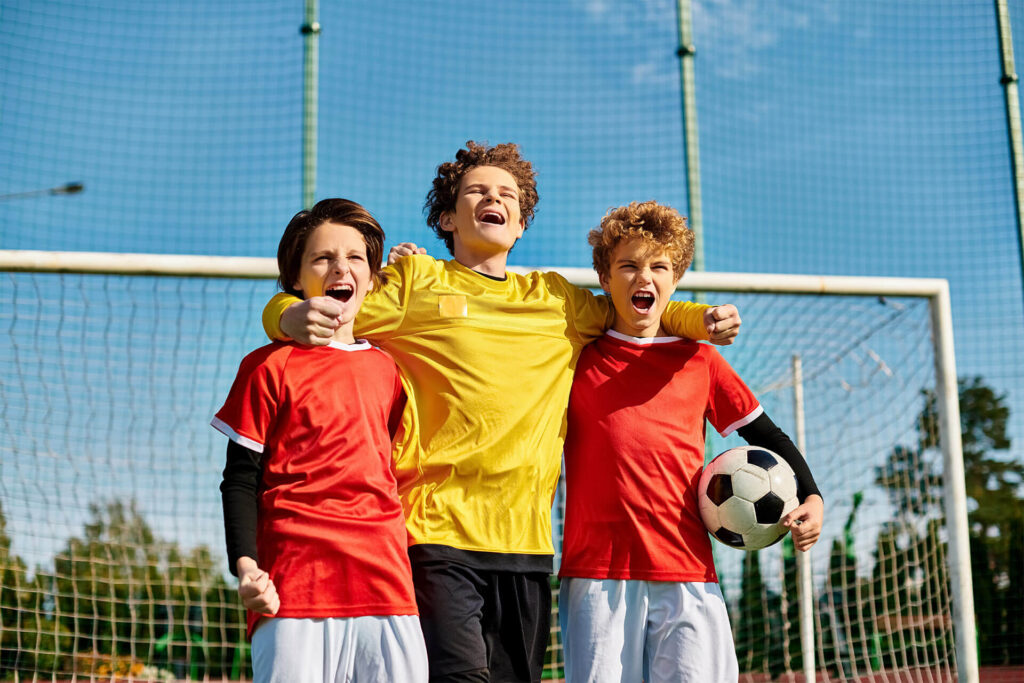 young boys stand closely together in unity on a green soccer field