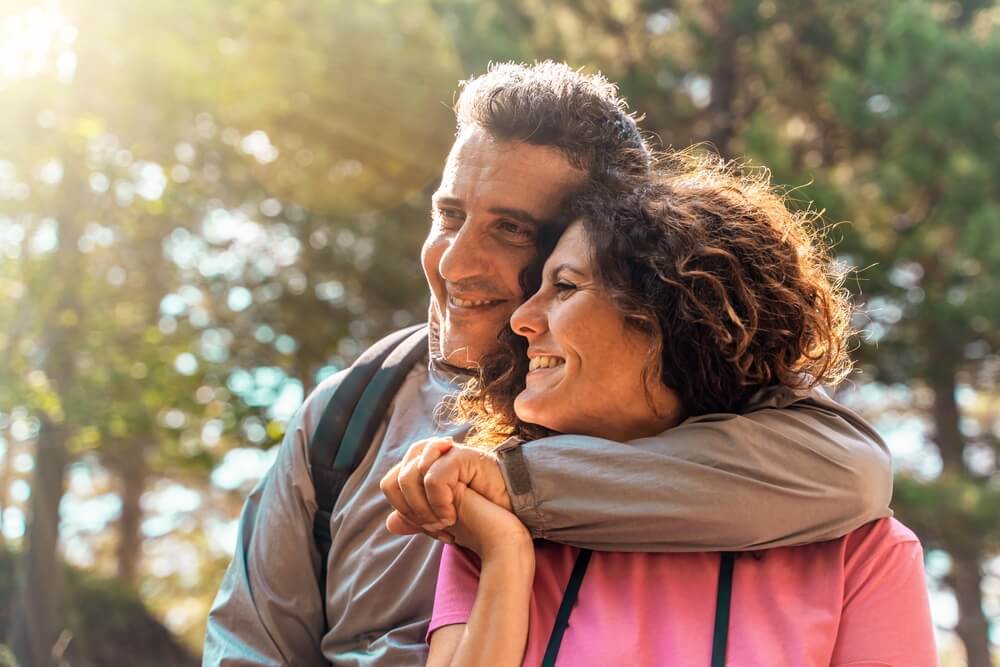 Joyful middle-aged couple embracing in a natural setting