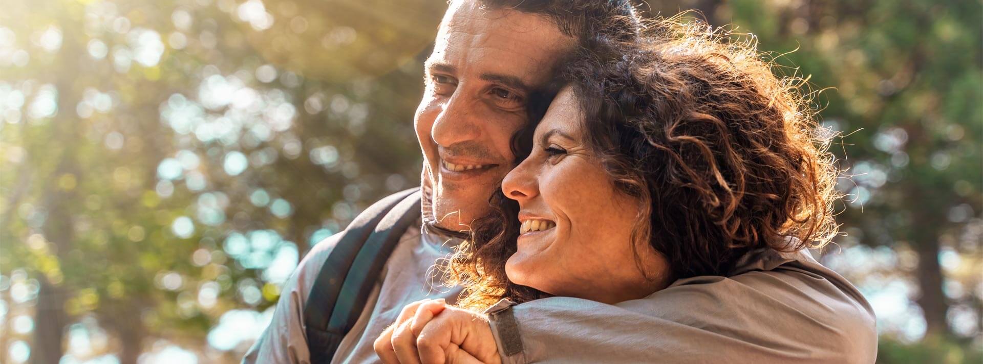 Joyful middle-aged couple embracing in a natural setting