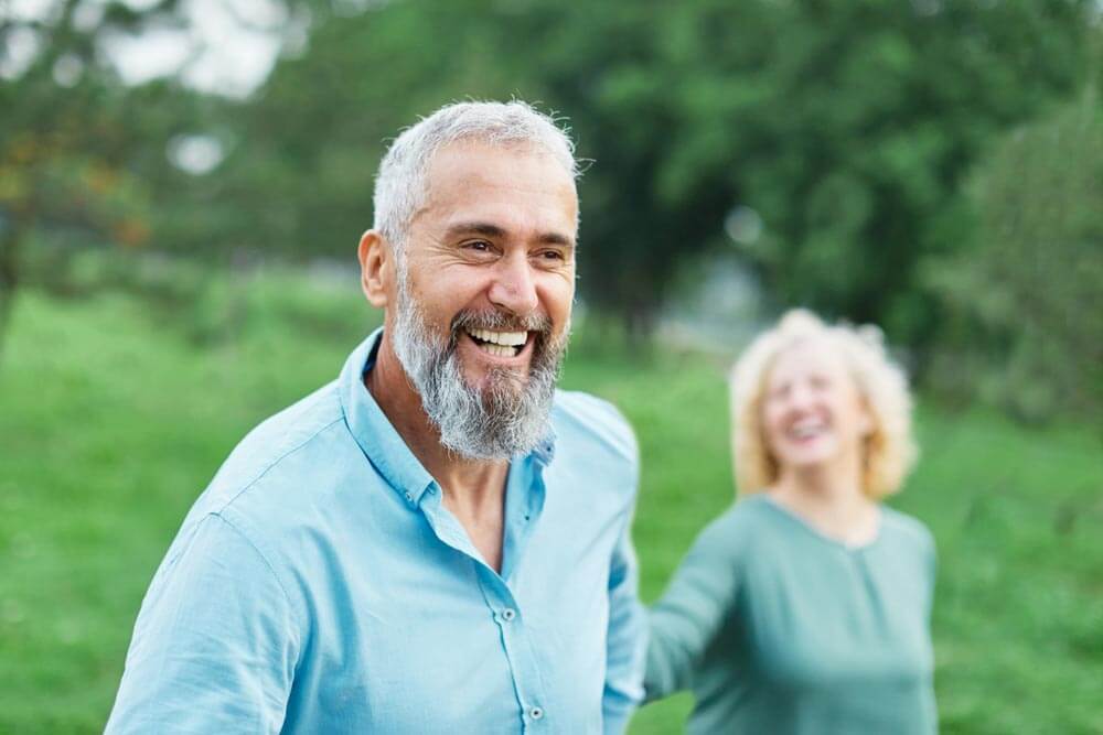 Happy active mid aged adult couple having fun walking