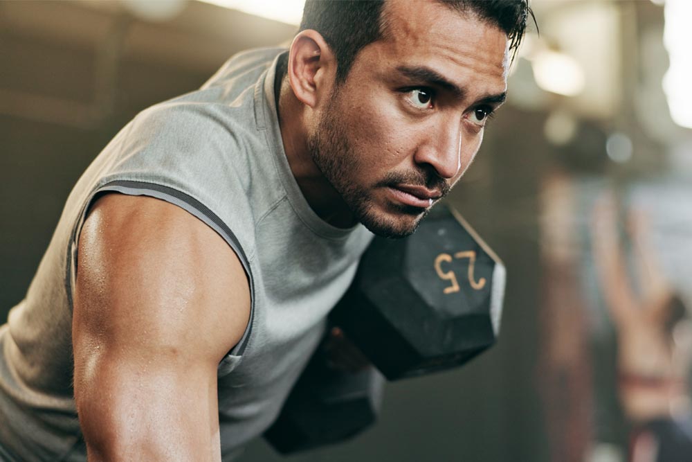 Active male person lifting weight for training