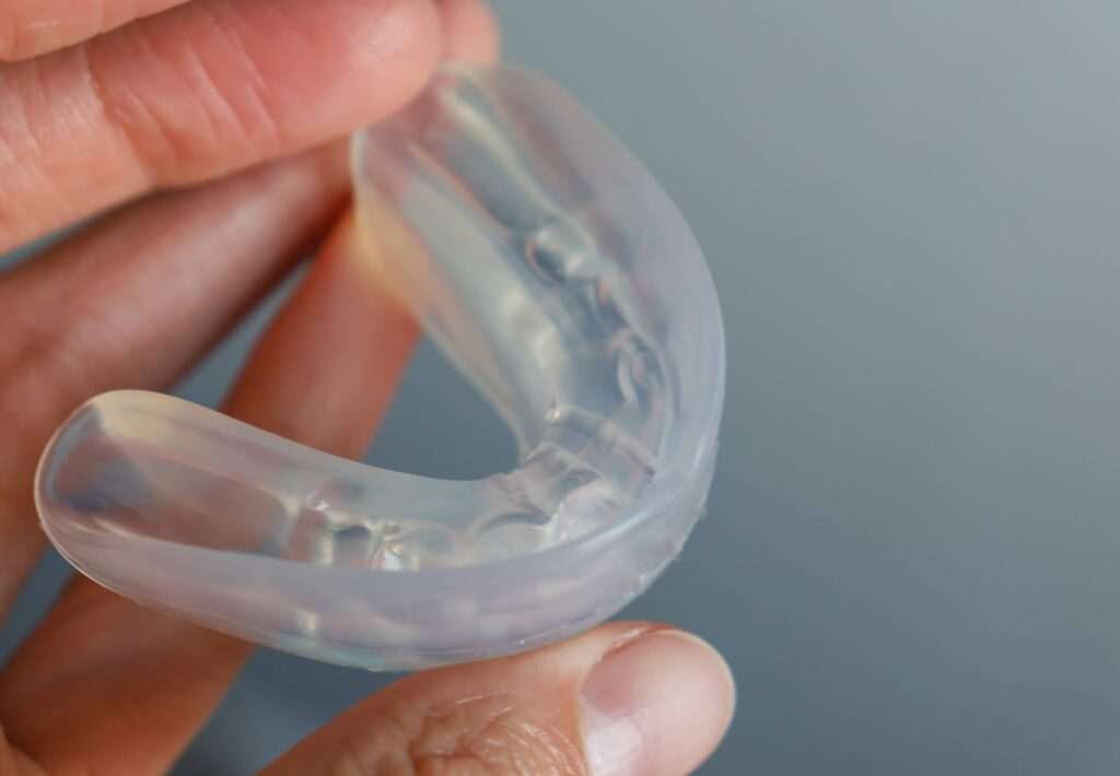 transparent mouth guard made of silicone, for straightening teeth in children, in a girl's hand, in daylight