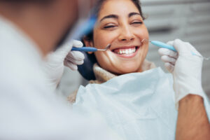 Over the shoulder view of a dentist examining a patients teeth in dental clinic