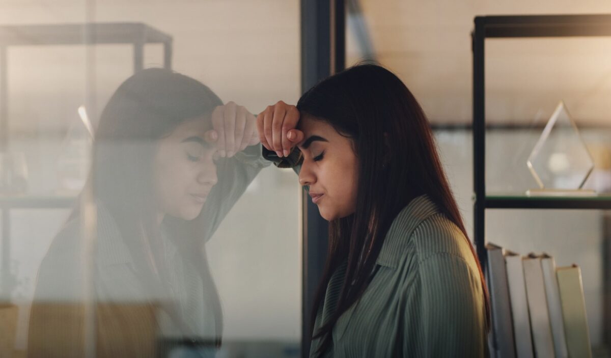 Stressed Female person standing against window