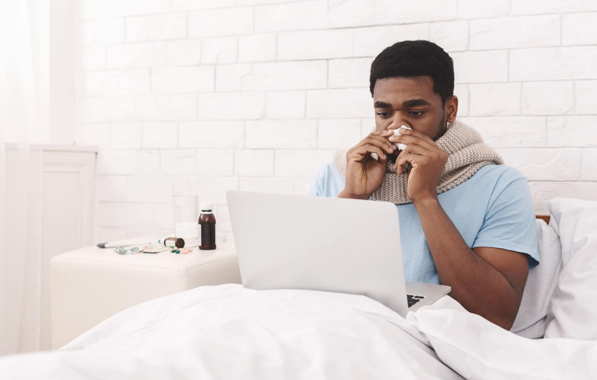 Sick student working from home on laptop