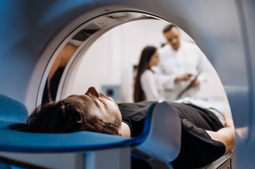 A patient undergoes an CT scan as doctors review images