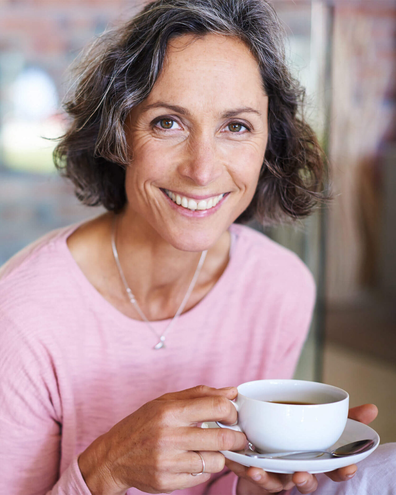 Smiling Mature woman drinking coffee at home