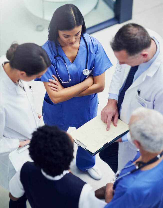group of doctors talking together over a medical chart