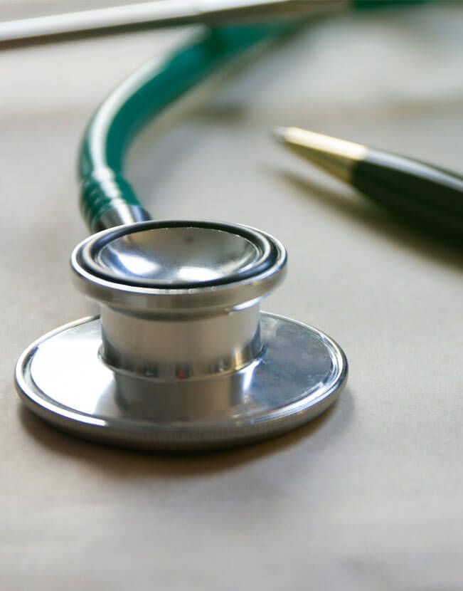 Stethoscope and pen on table