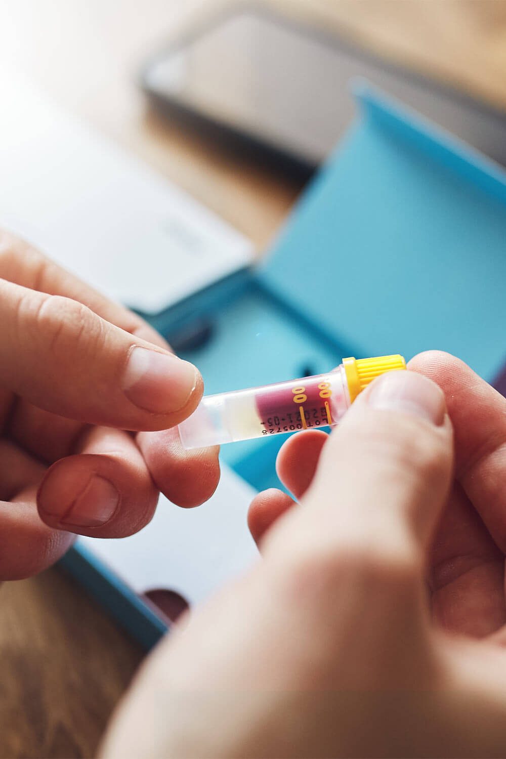 Home blood test with man holding test tube sample