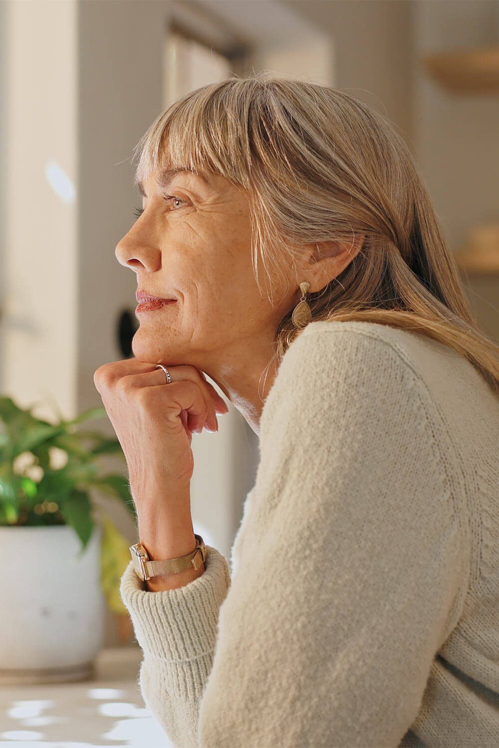 Elderly woman thinking while looking outside the window