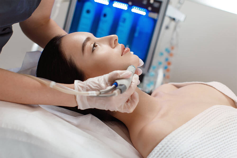 Professional female cosmetologist doing hydrafacial procedure in Cosmetology clinic
