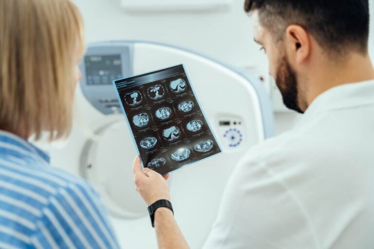 A man and a woman are looking at a medical image of a brain