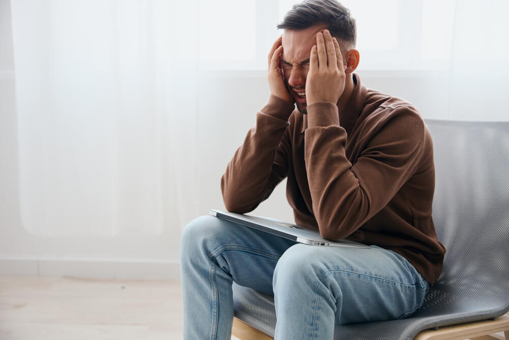 Upset young man feels pain in back of head