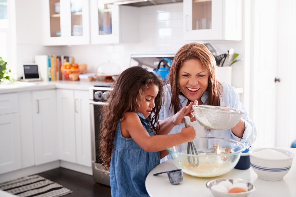 Young,Hispanic,Girl,Making,Cake,In,The,Kitchen,With,Her