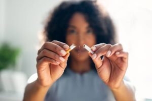 woman breaking down cigarette to pieces