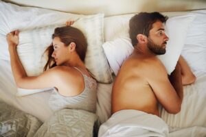 Frustrated couple on bed after argument
