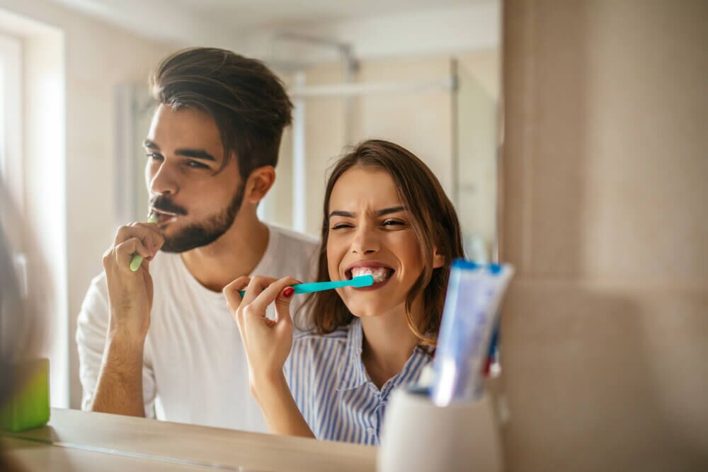 happy couple brushing teeth in the bathroom