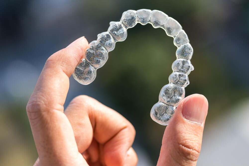 Hand Holding Invisalign braces