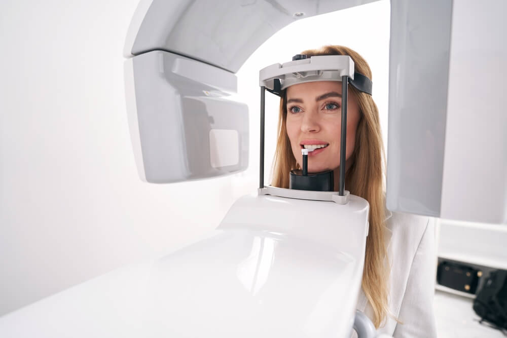 Woman using dental diagnostic equipment in clinic