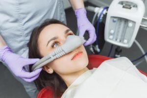 dentist puts inhalation sedative mask on his patient