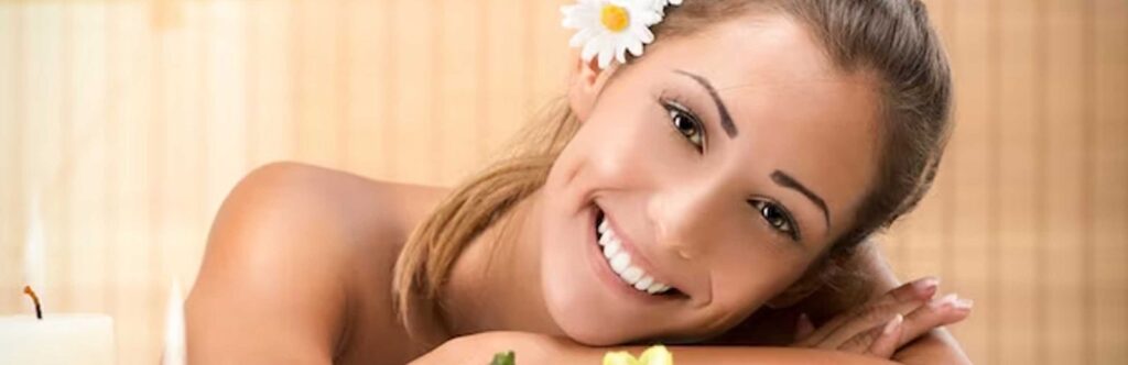 Smiling woman lying on massage table at the health spa