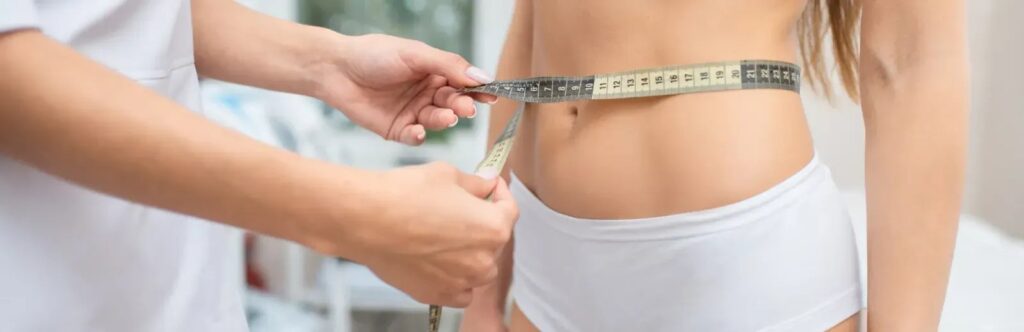 woman measuring her waist