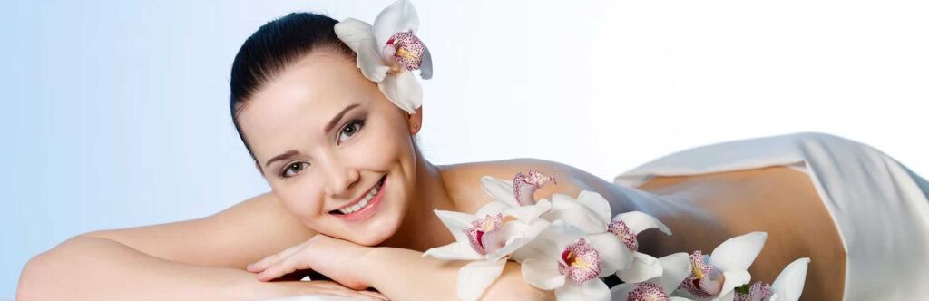 Smiling woman lying on massage table at the health spa