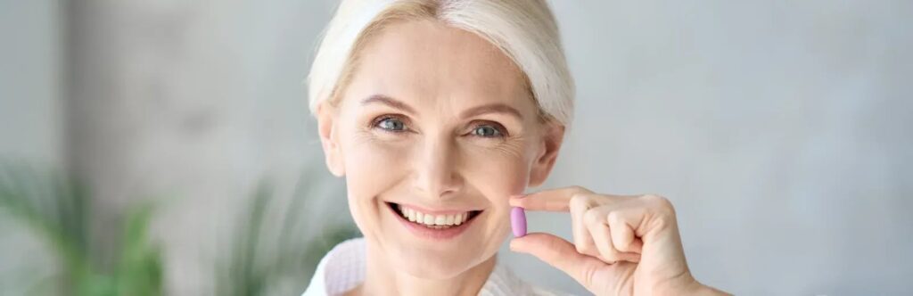 Beautiful mid-age woman holding pill in hand