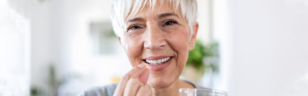 happy woman holds pill glass of water