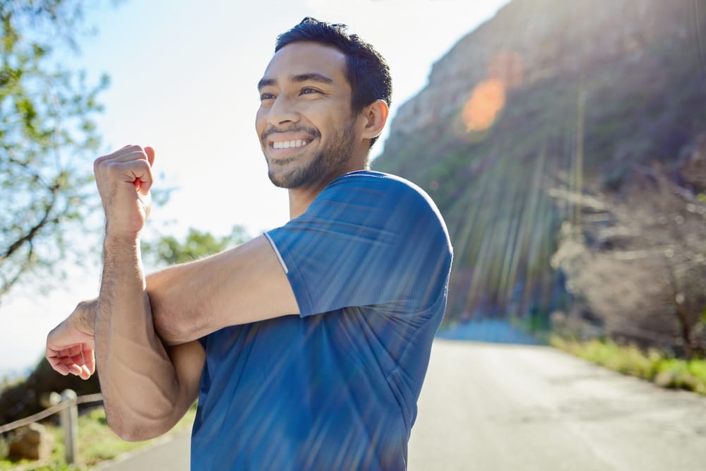 Fitness, thinking and stretching with a man runner outdoor
