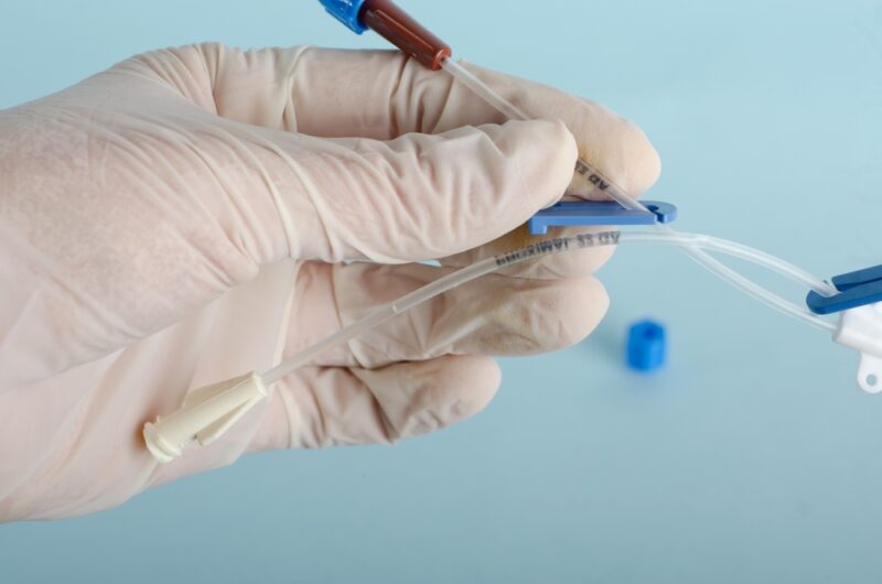 Central catheter kit elements, dilators, channeling needles. Instruments for surgery, surgery table, Isolated on light blue background, closed angle.