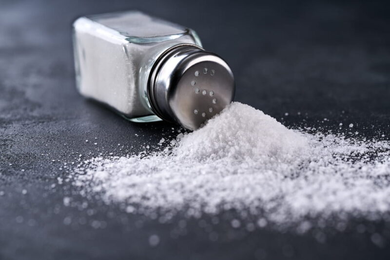A pile of salt from salt shaker, concept excessive salt intake.