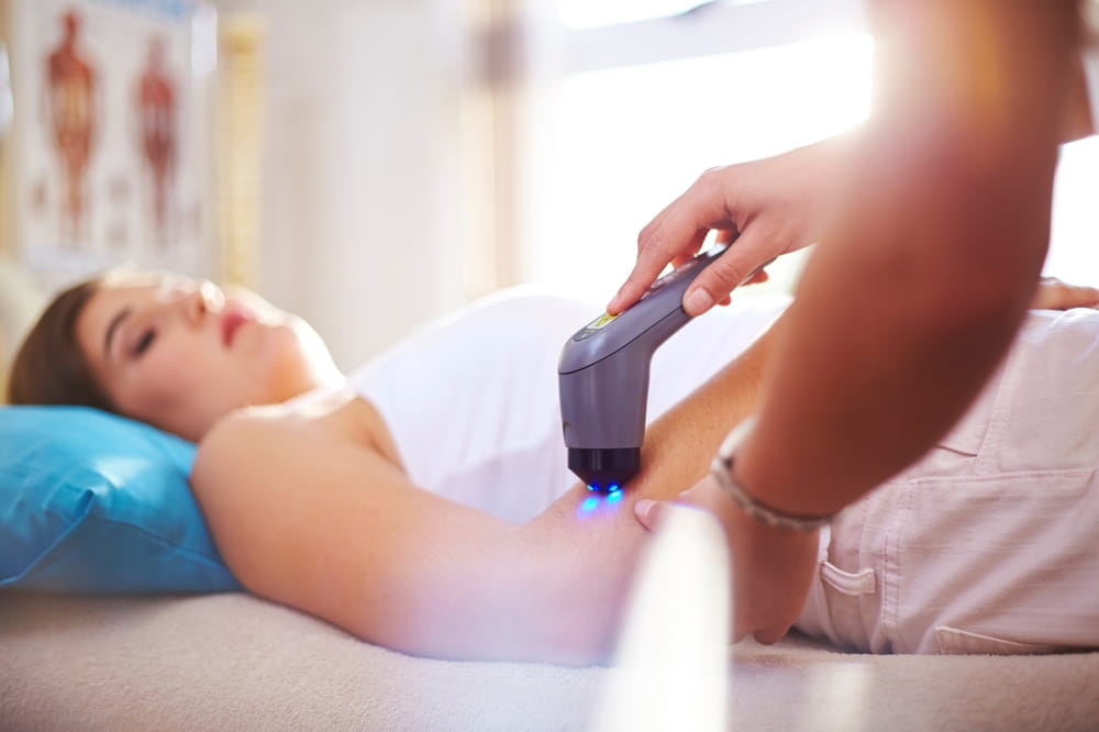 Physical therapist using ultrasound probe on woman's arm