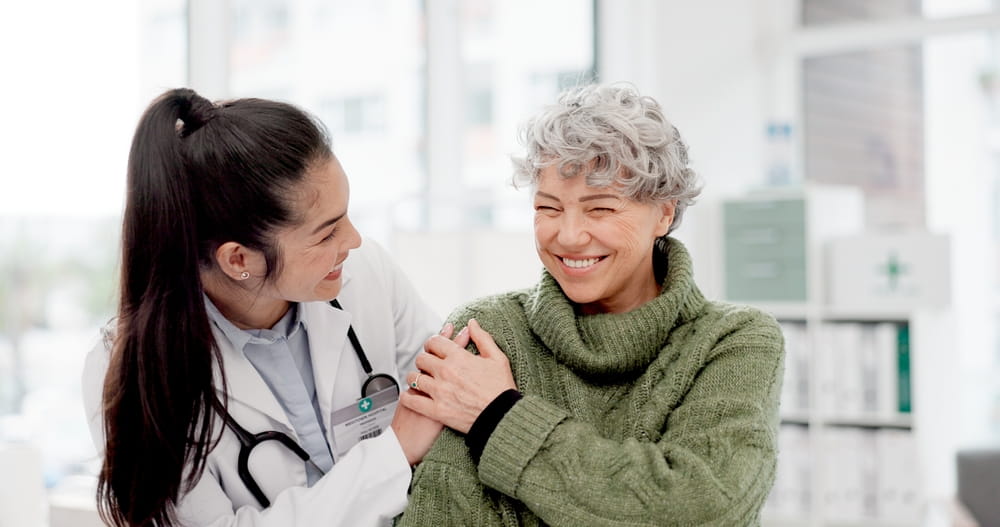 Happy, care and face of a doctor with a woman for medical trust, healthcare and help