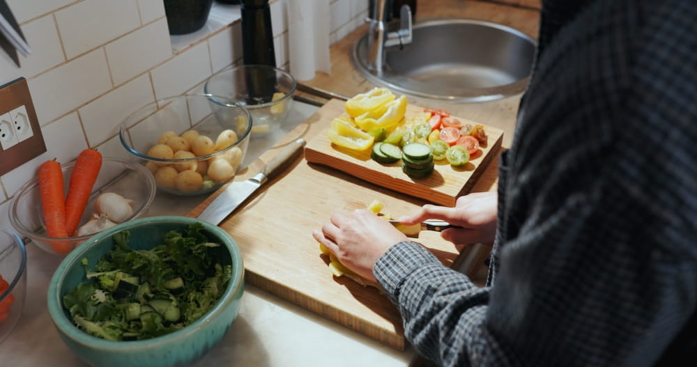 Cooking, above and hands of man with vegetables for meal prep, healthy lunch and dinner in home.