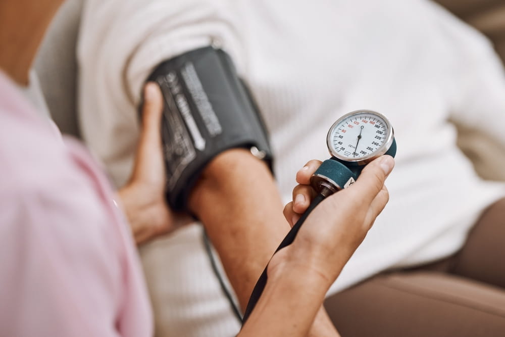 Blood pressure, hypertension and nurse with patient to check diabetes, healthcare consulting and service in clinic.