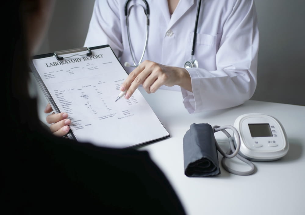 A female doctor and a patient are listening and explaining the results of the examination, emphasizing personal care in a hospital.