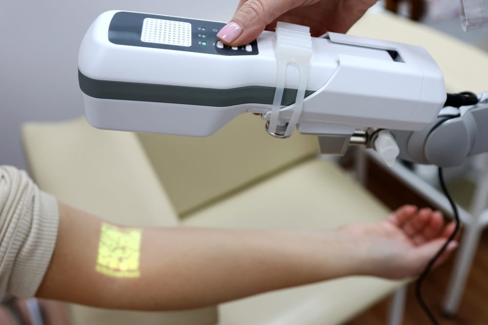 The doctor uses a portable non-contact device to visualize the veins.