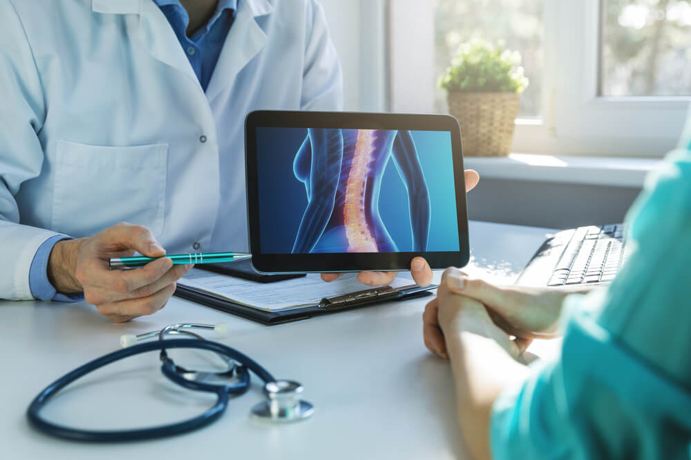 Doctor and patient talking about back pain treatment in clinic office