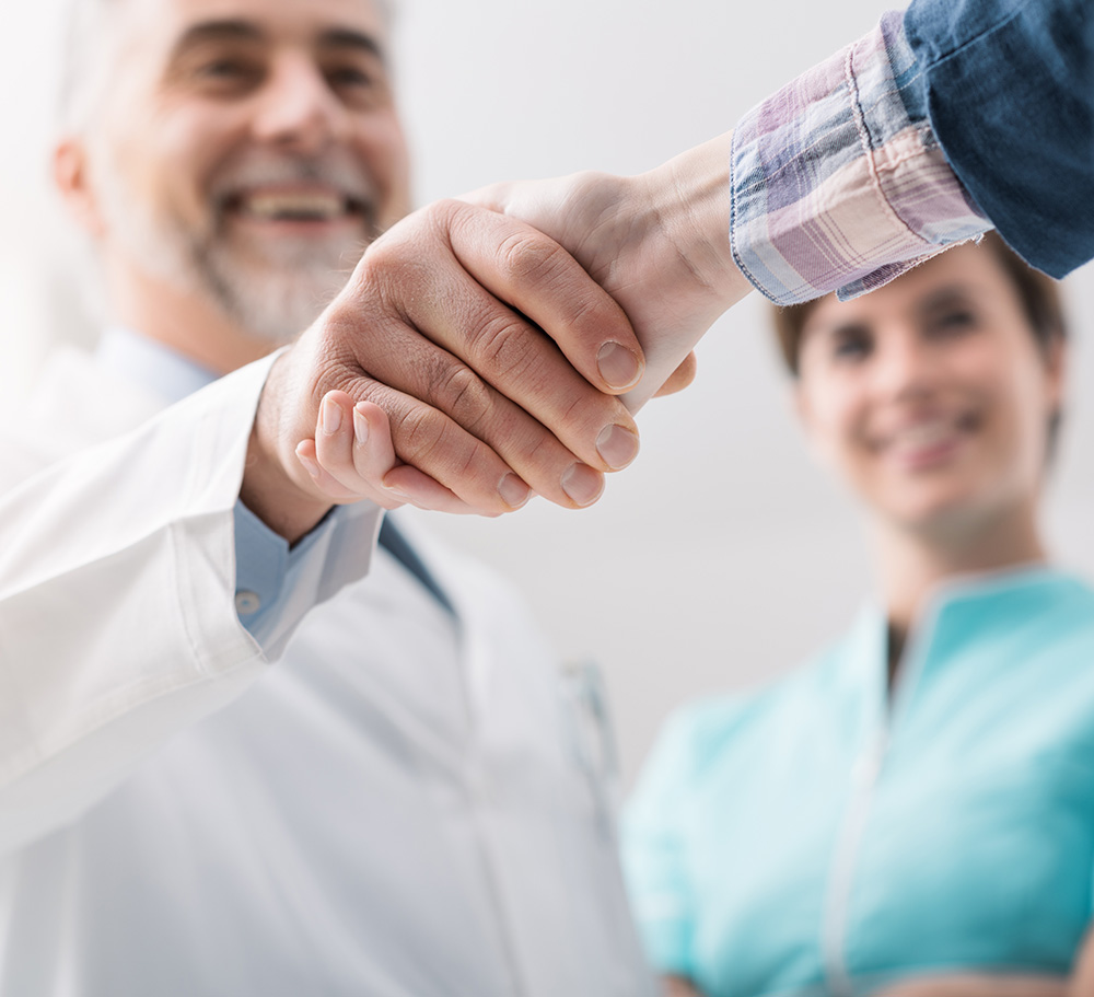 Doctor and female patient meeting at the hospital and shaking hands, healthcare and medicine banner