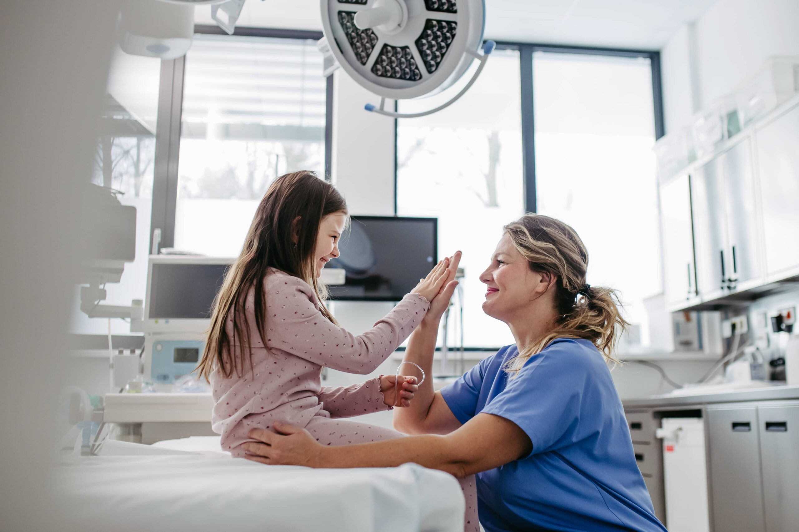 Supportive doctor high five with children patient in emergency room