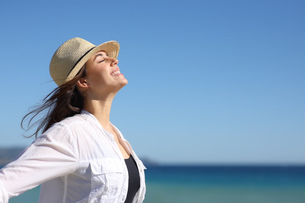 Side view portrait of a happy woman on the beach