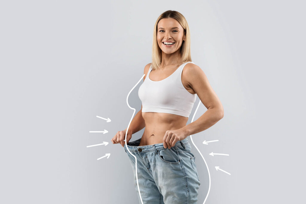 Cheery attractive woman wearing huge jeans, showing results of diet