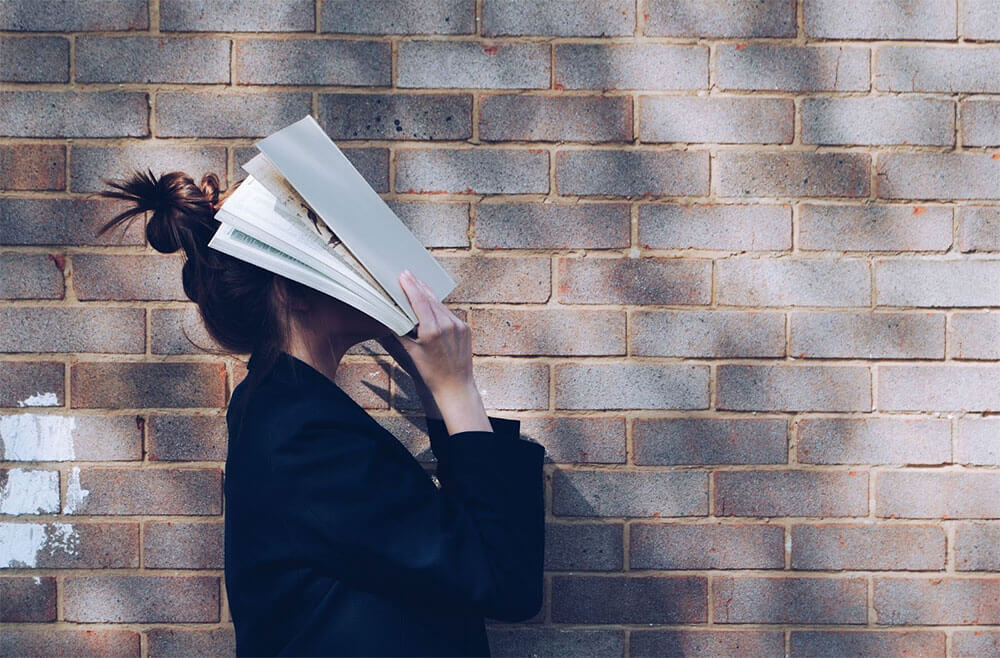 Woman face covered with book