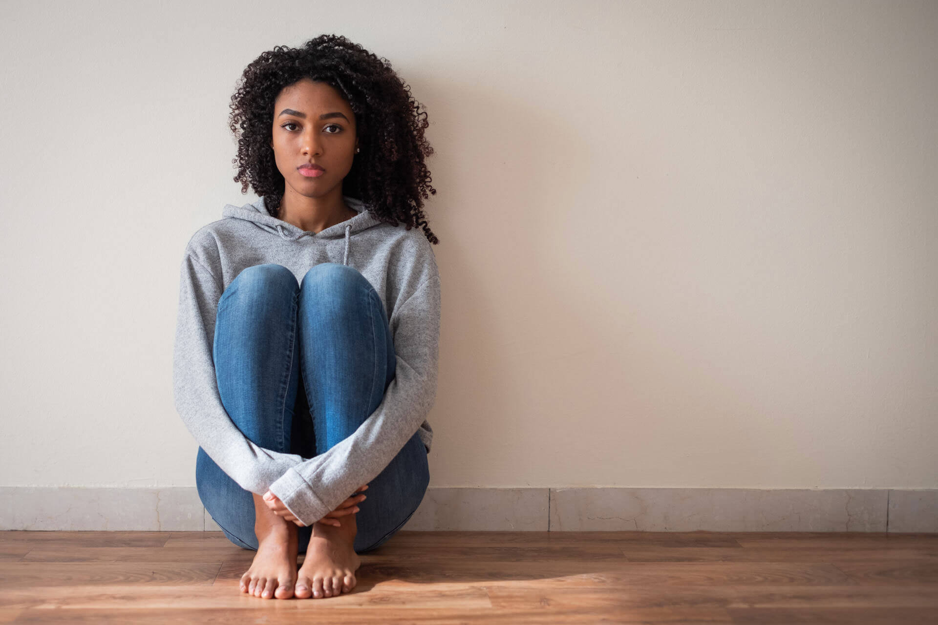 Teenage sitting on floor in sad mood